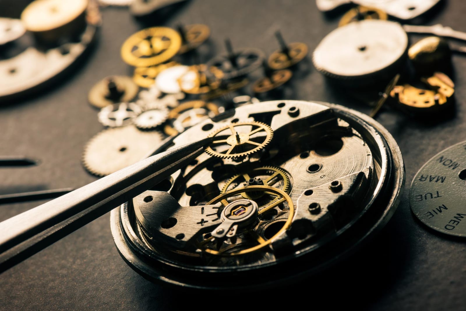 Tecnico al lavoro su un movimento di orologio, laboratorio a Milano